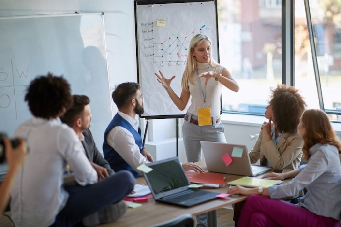 Business woman present her idea to working team workshopping software development idea